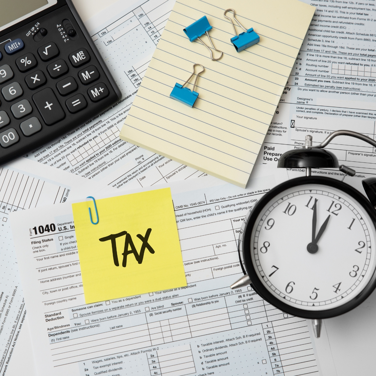 Tax season with calculator, clock, tax forms, and paper clips